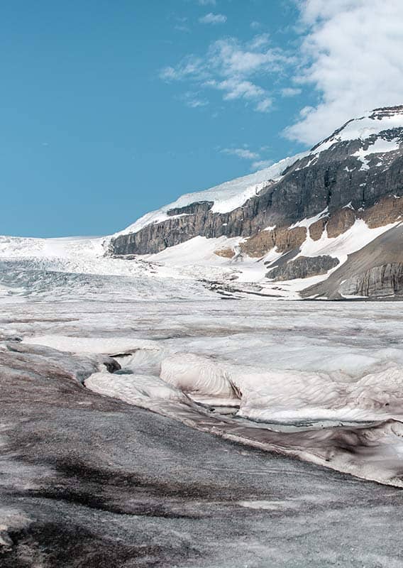 A view of a glacier below tall cliffsides.