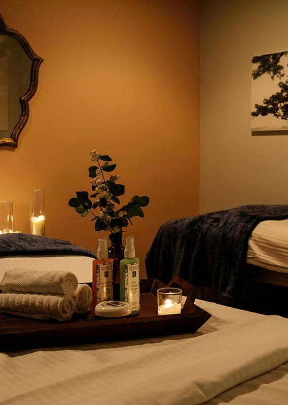 Two massage  beds in a dimly lit room.