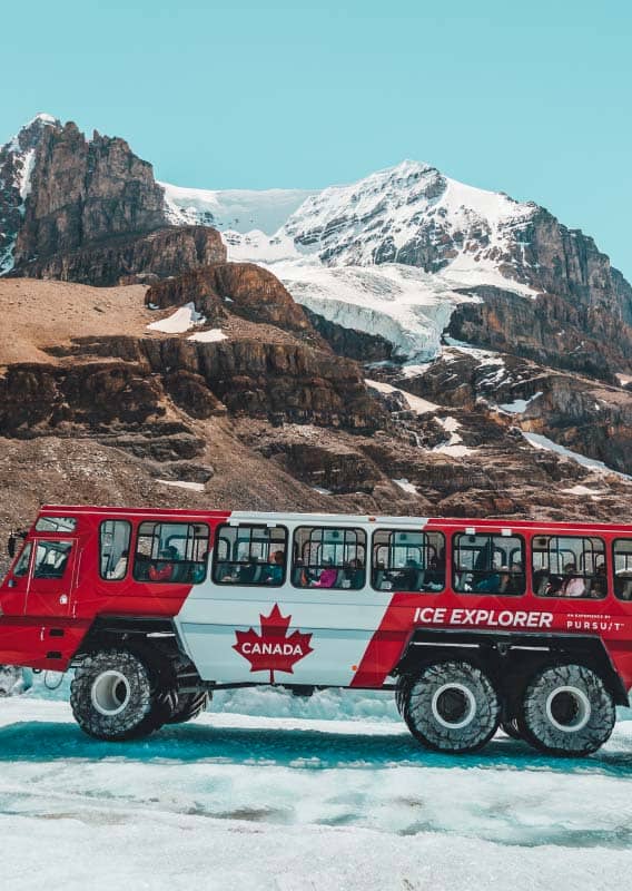 Columbia Icefield Adventure Ice Explorer bus driving along ice road under mountains and glacier view