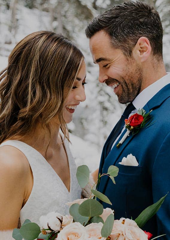 A newlywed couple smile close together.