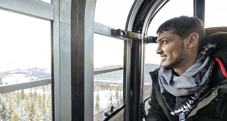 A man looks out the window in a Banff Gondola shuttle