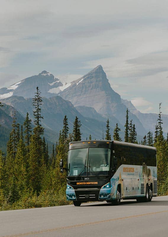 Brewster Express bus driving along highway with mountains in the distance.