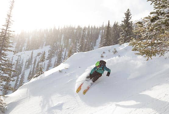 A person skiing down a steep slope.