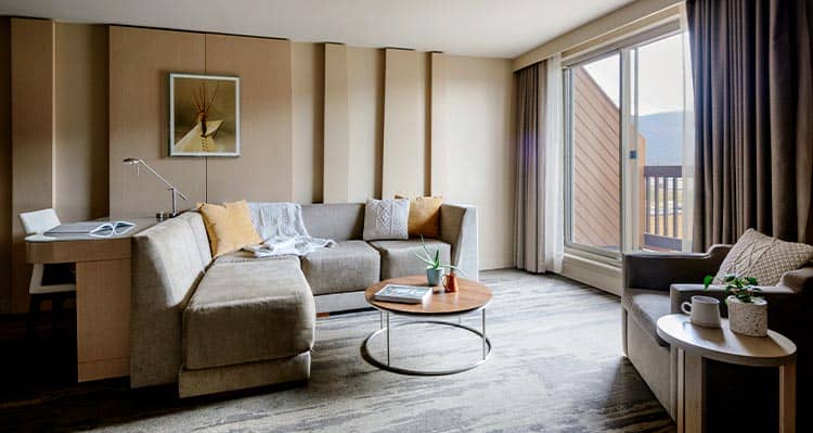 A hotel room lounge with a big window and balcony