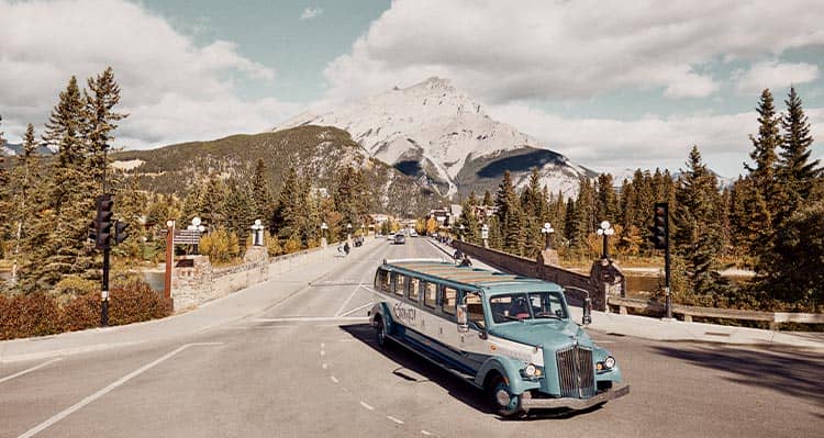 Blue and white bus drives across the bridge.