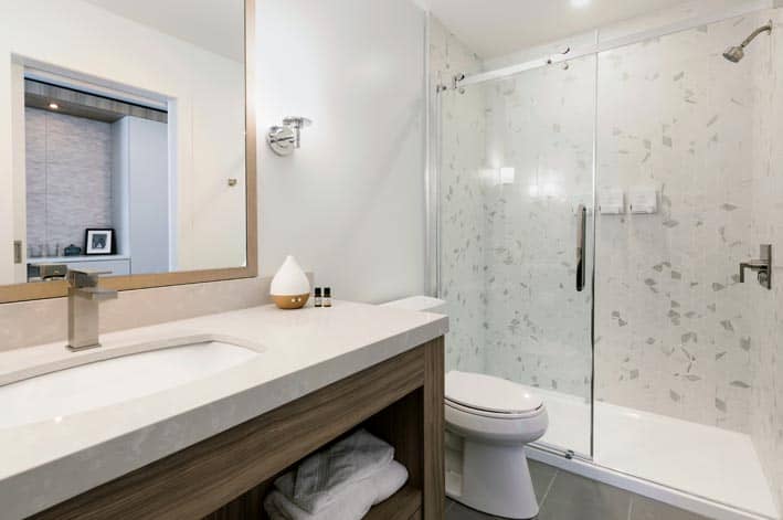 A tiled shower, toilet and sink in a modern bathroom