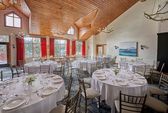 The interior of a dining room with high ceilings, set up for a wedding.