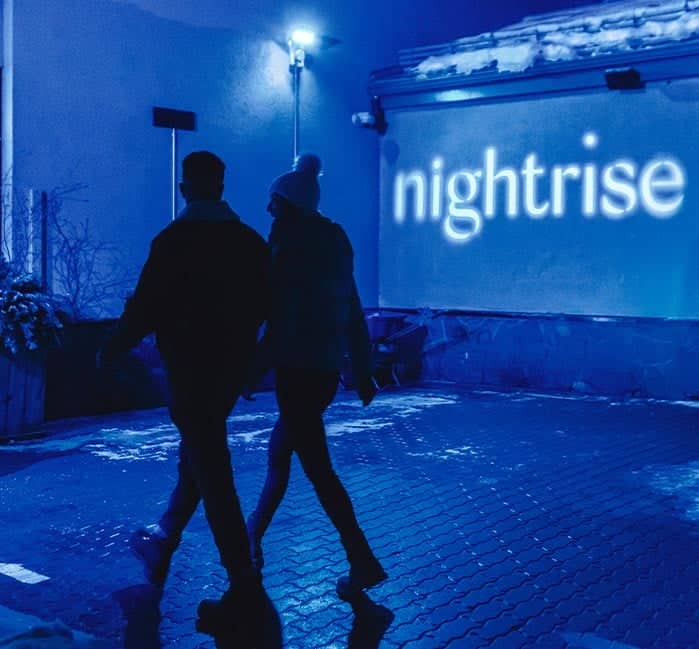 Two people at Nightrise at night.