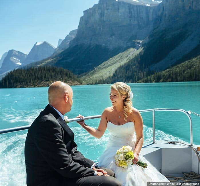 A bride walks on a high mountain balcony.