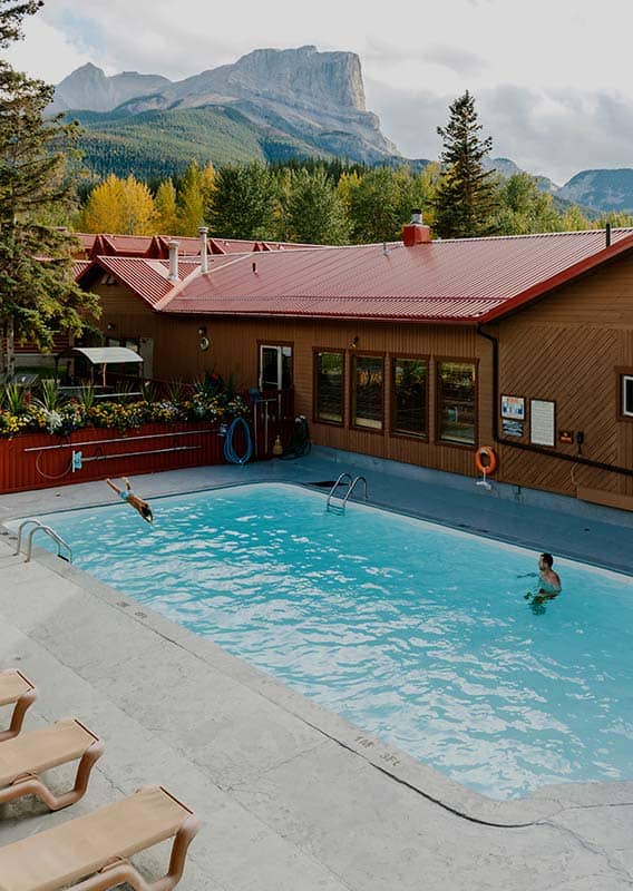 A man swims in a pool outdoors